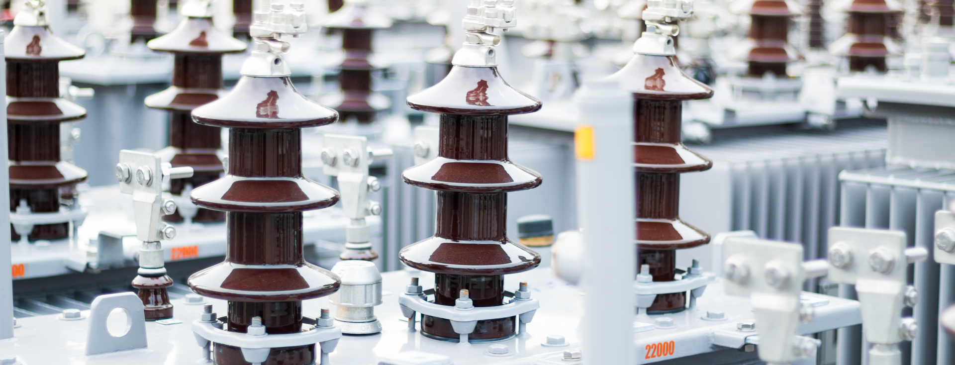 rows of brown porcelain insulators on large gray transformers rows of brown porcelain insulators on large gray transformers