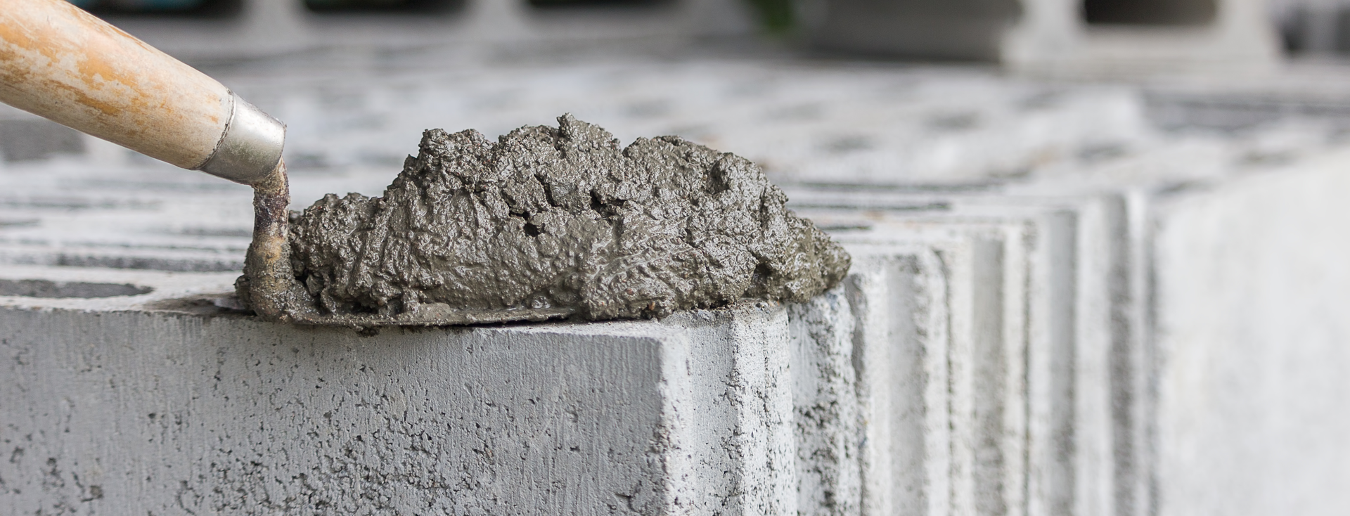 Bricklayer's trowel with mortar lies on stacked hollow concrete blocks Bricklayer's trowel with mortar lies on stacked hollow concrete blocks
