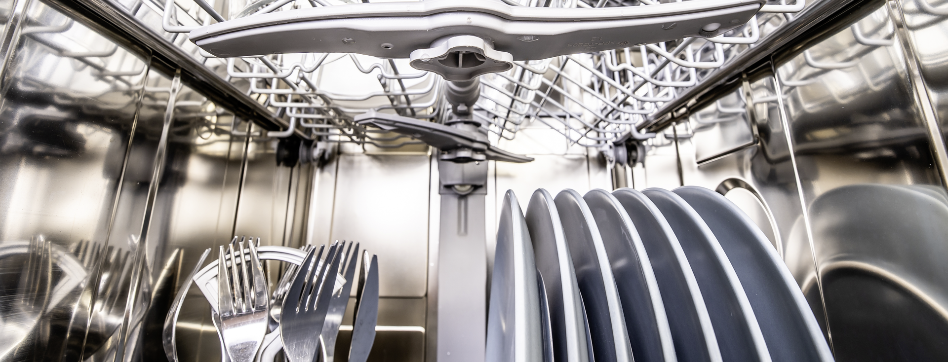 Inside view of a loaded dishwasher with clean dishes