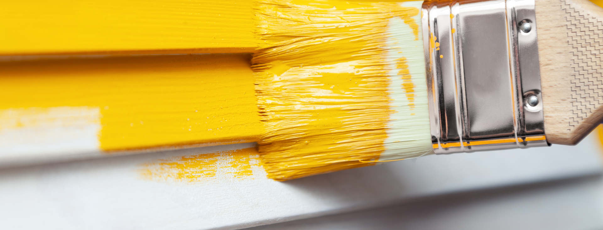 yellow paint is applied to a white wooden wall with a brush yellow paint is applied to a white wooden wall with a brush