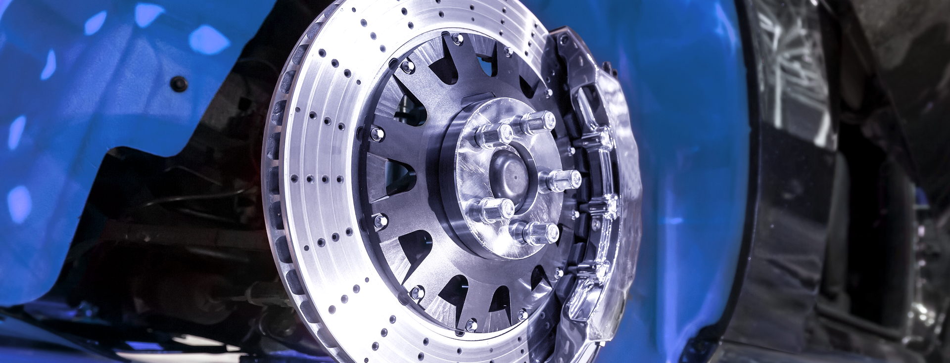 close-up of the silver brake disc of a blue car