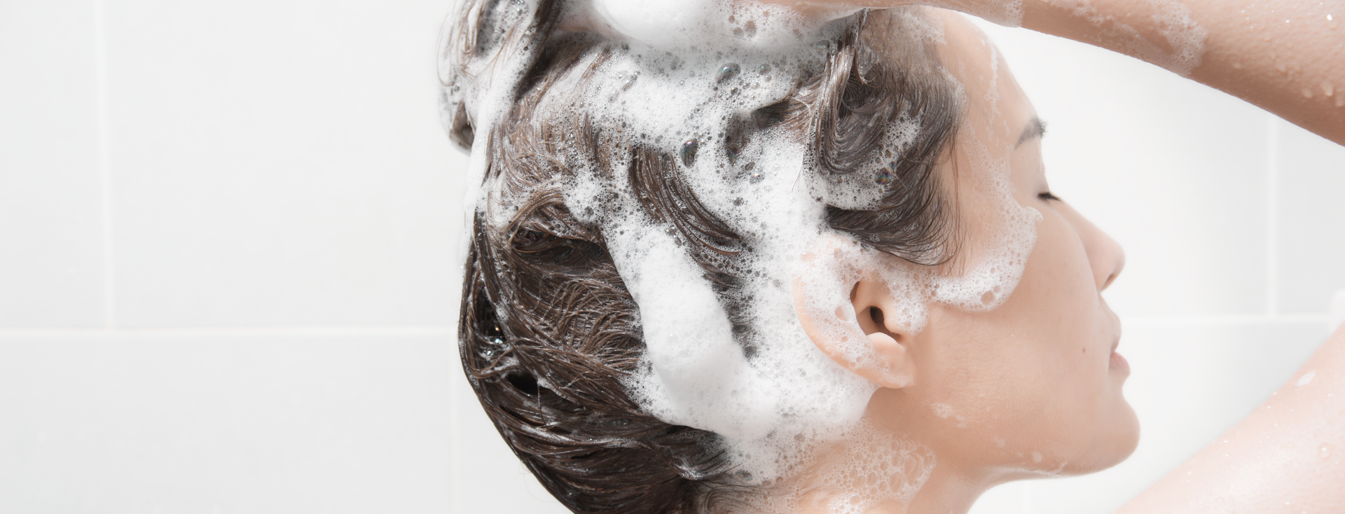 woman lathering and washing her hair woman lathering and washing her hair