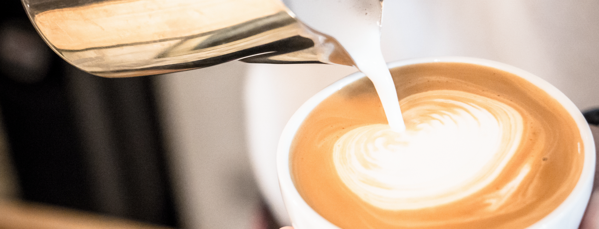 barista pours milk foam into a cup of cappuccino barista pours milk foam into a cup of cappuccino