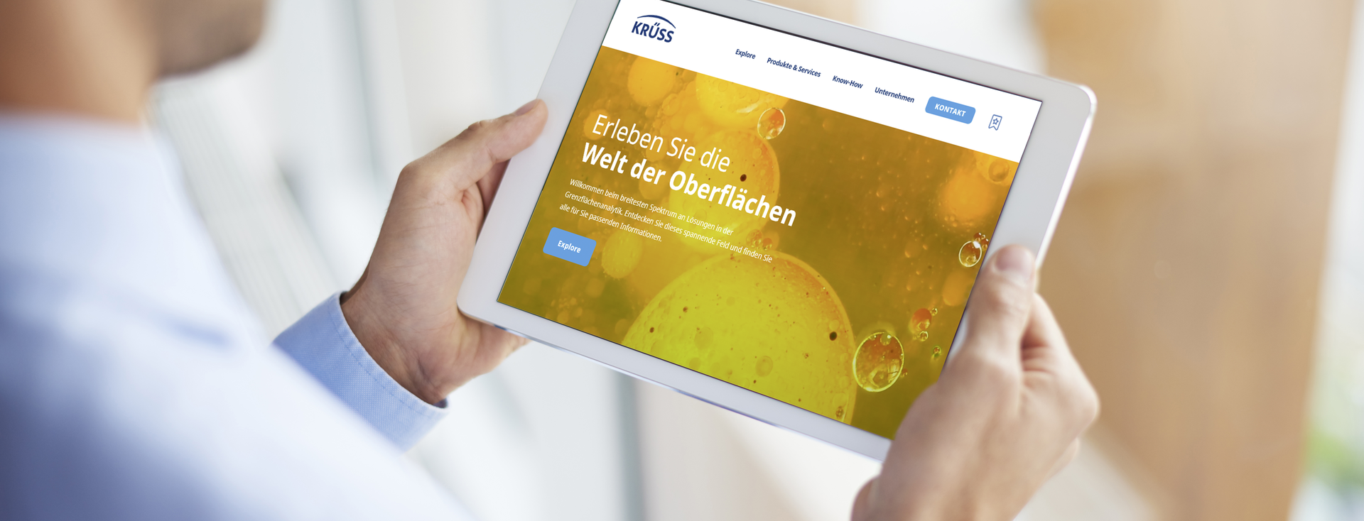 Mann besucht auf einem Tablet die deutsche Krüss Website