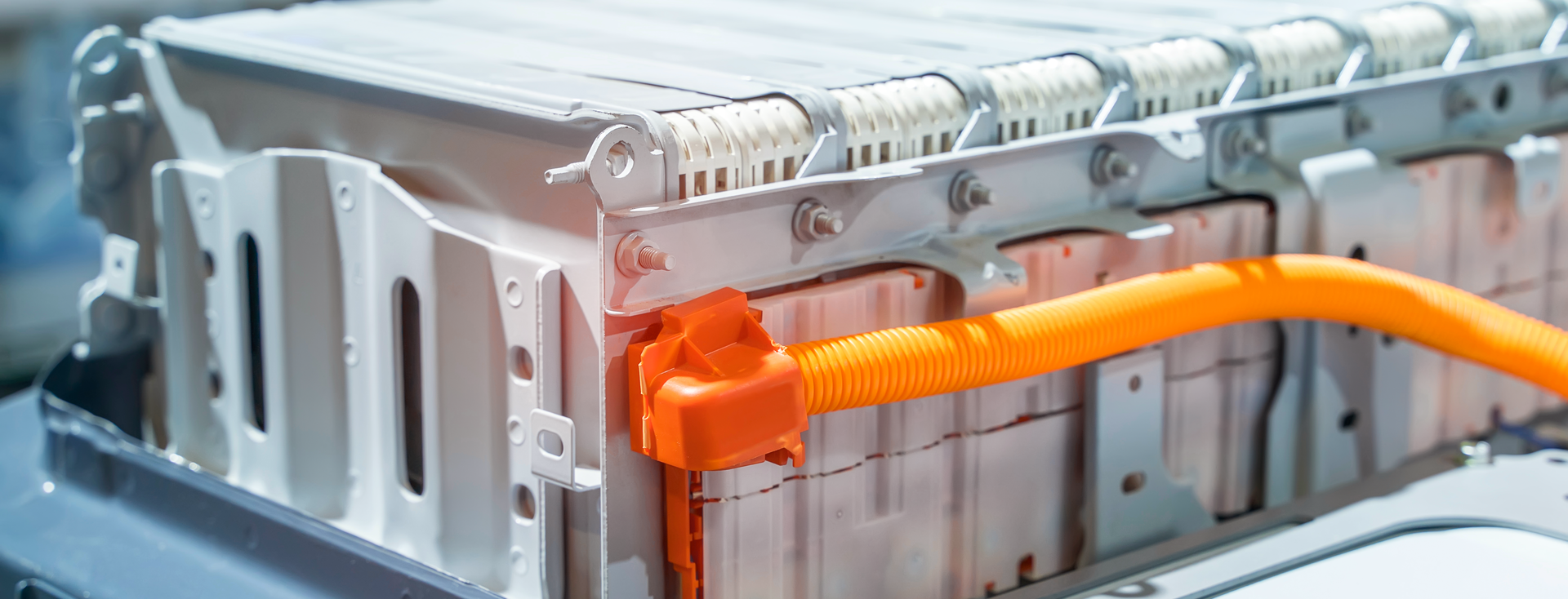 close-up of a large lithium-ion battery pack in an electric vehicle with an orange cable close-up of a large lithium-ion battery pack in an electric vehicle with an orange cable